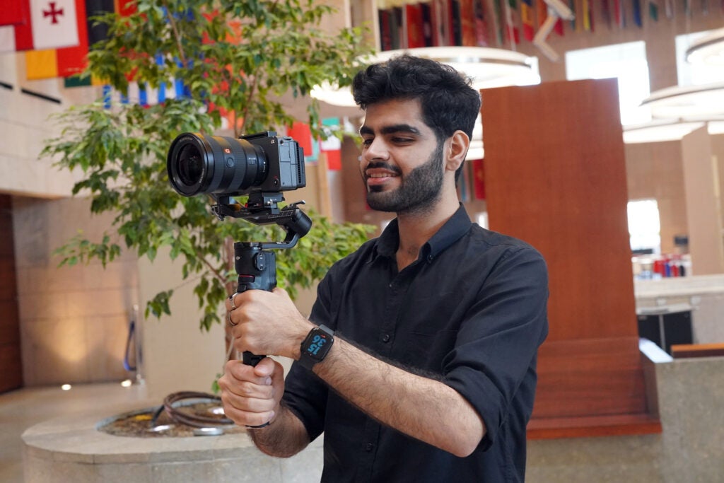 student with a video camera and equipment